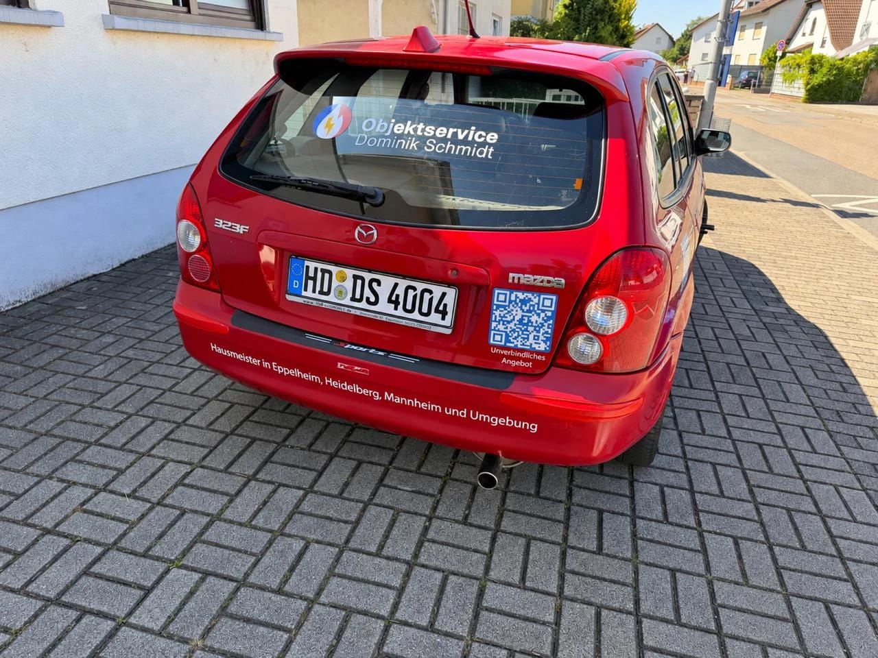 Heckansicht mit Logo auf der Heckscheibe, QR-Code für ein unverbindliches Angebot und Einsatzgebieten auf der Stoßstange